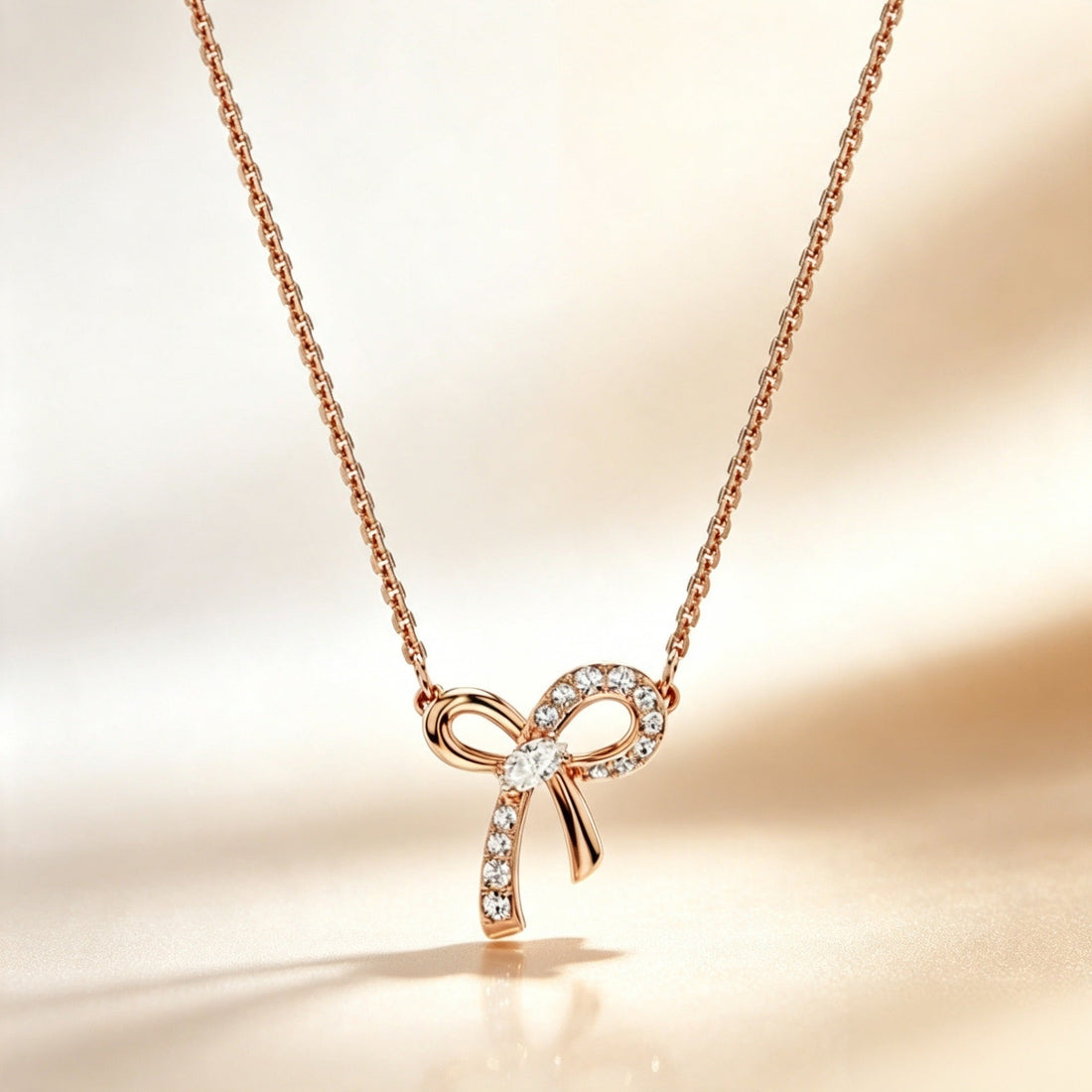 Rose gold-tone bow pendant necklace with clear pavé accents