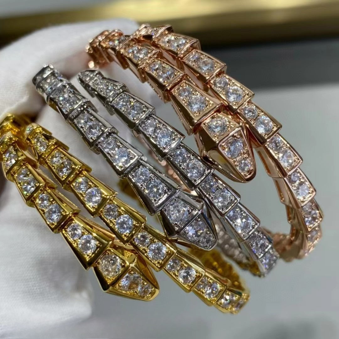 Gold-tone open snake wrap bracelet with geometric segments and clear faceted accents