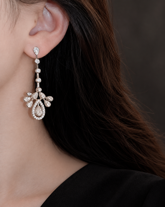 Four-link CZ chandelier earring with crown and teardrop detail beside a black dress neckline