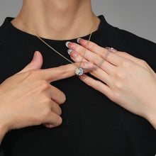 Two people wearing matching magnetic sun and moon pendant necklaces