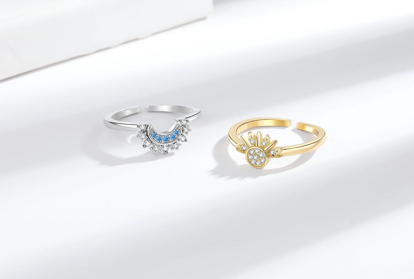 Gold-tone sun ring and silver-tone moon ring displayed on a white background