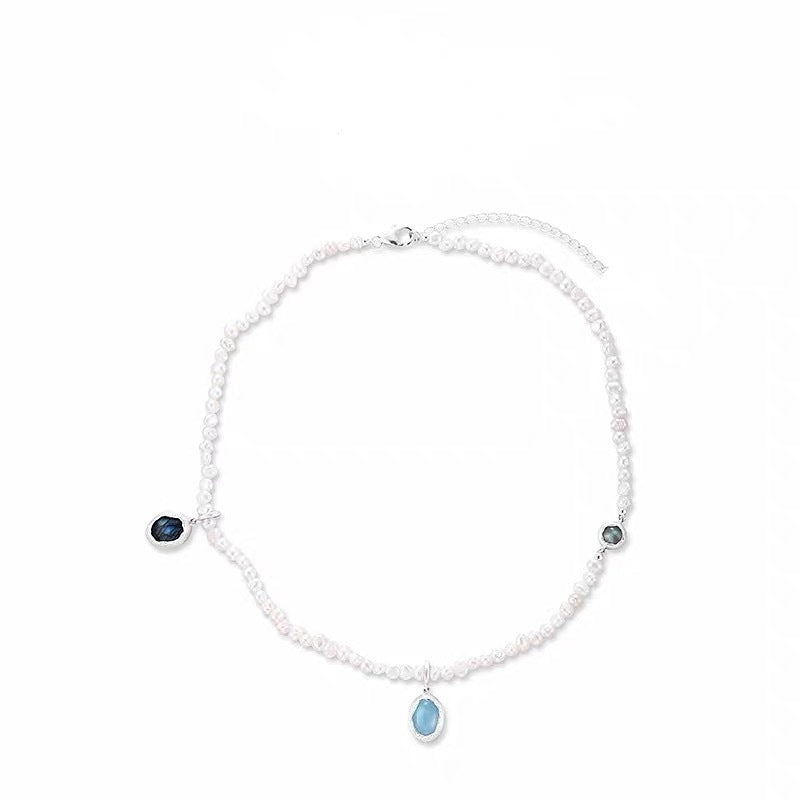 Ocean-inspired white beaded necklace with blue drop charms