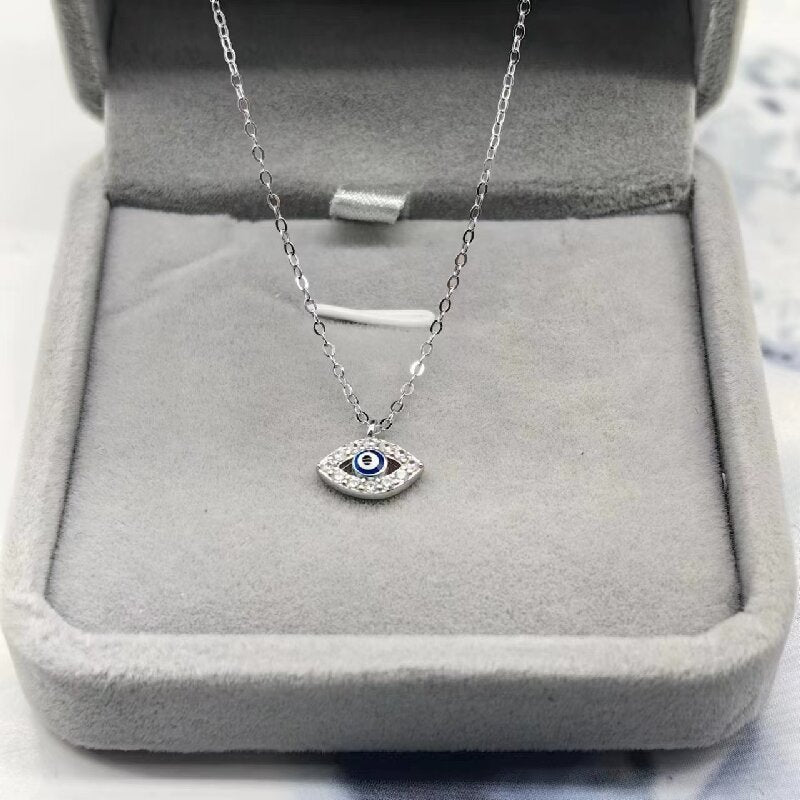 Silver-tone evil eye pendant necklace displayed in a jewelry box