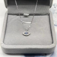 Silver-tone evil eye pendant necklace displayed in a jewelry box