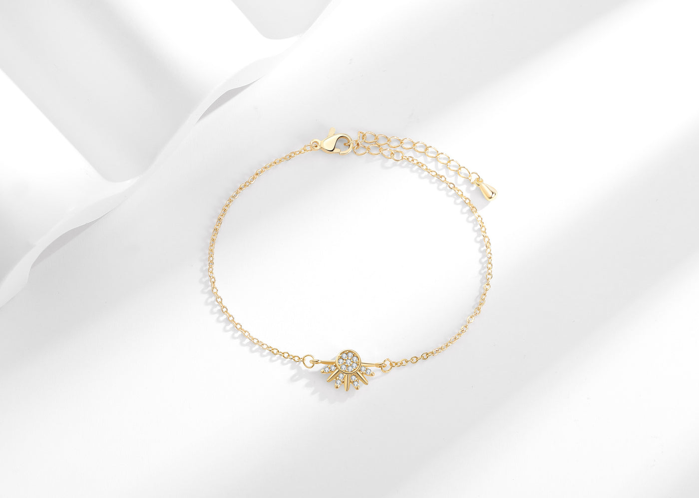 Gold-tone sun zircon bracelet with extension chain on a white background