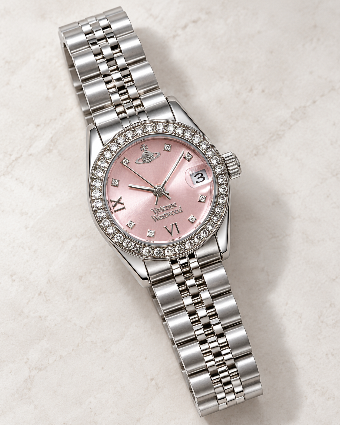 Pink dial bracelet quartz watch showing sparkling bezel, magnified date window and silver-tone steel links