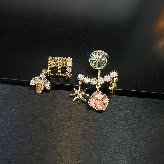 Asymmetrical gold-tone celestial earrings with compass, star and floral charms