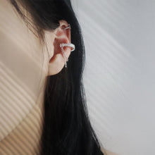 Side view of a crystal double-chain ear cuff worn on the ear with other jewelry