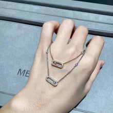 Rose gold and silver-tone open link necklaces layered on hand