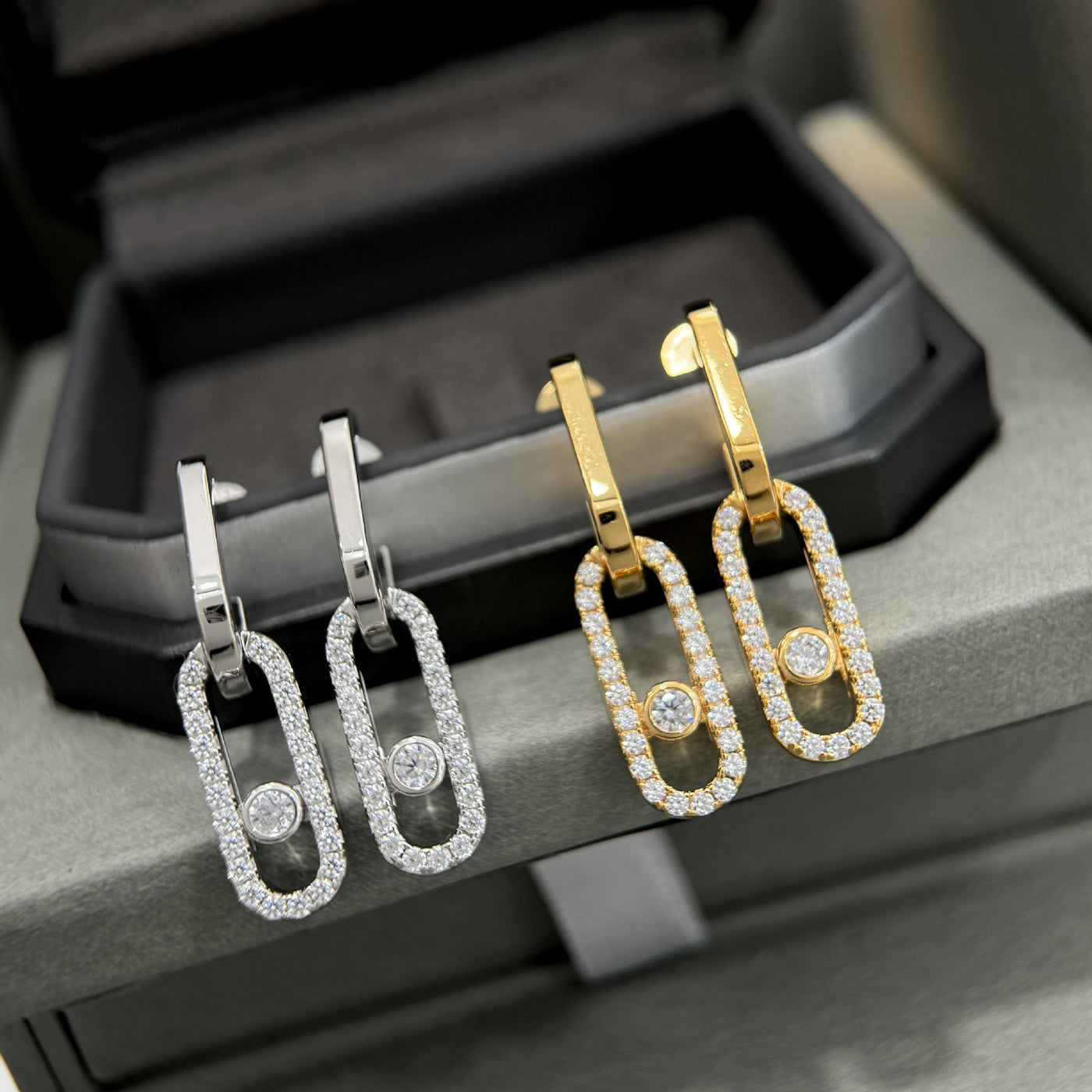 Silver and gold-tone CZ sliding stone drop earrings shown together