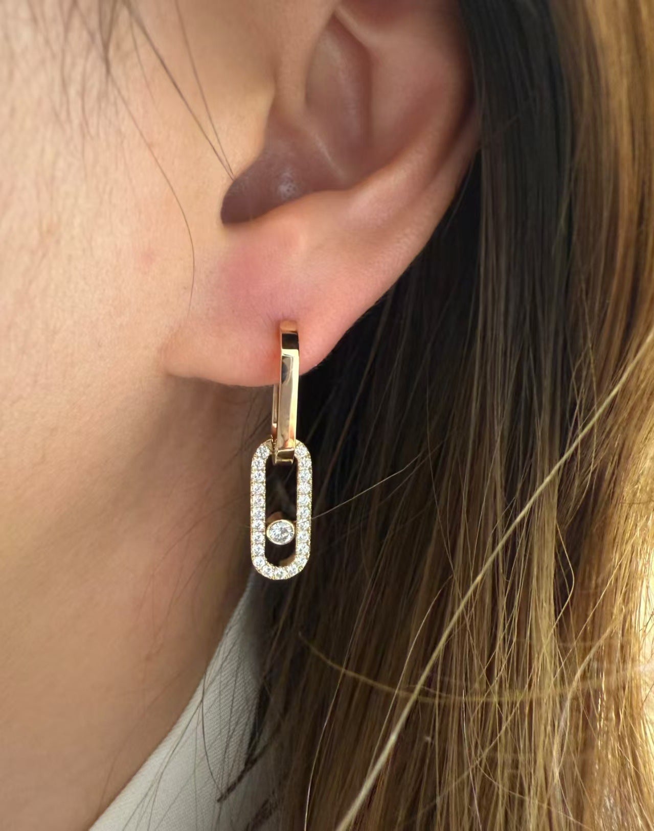 Gold-tone pavé CZ open link drop earring worn on the ear
