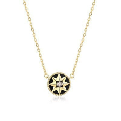 Gold-tone black-inlay eight-point star compass pendant necklace on a white background