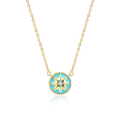 Gold-tone turquoise-inlay eight-point star compass pendant necklace on a white background