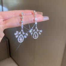 Sparkling crown-detail CZ chandelier earrings held as a pair
