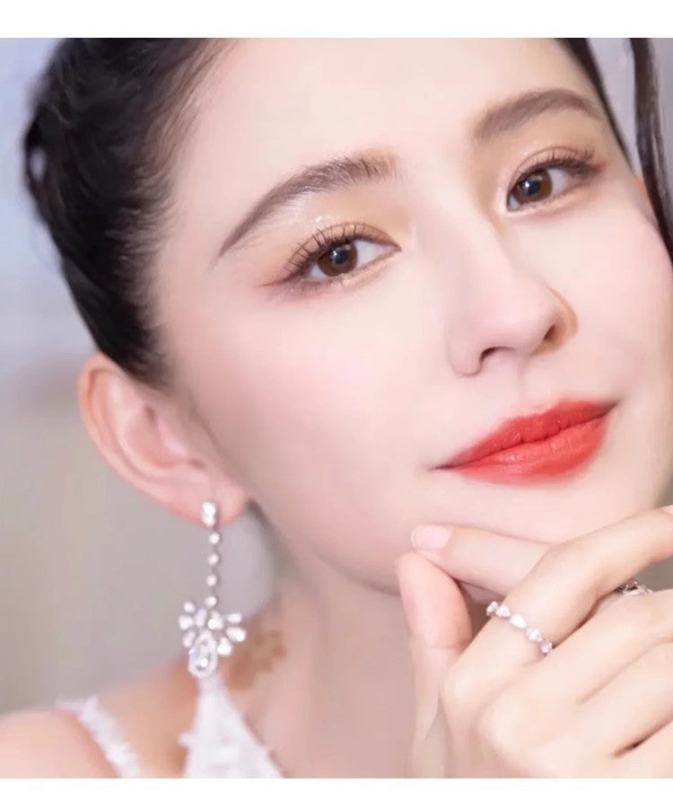 Model wearing long teardrop CZ chandelier earrings in silver tone