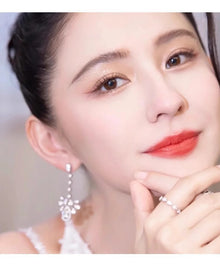 Model wearing long teardrop CZ chandelier earrings in silver tone