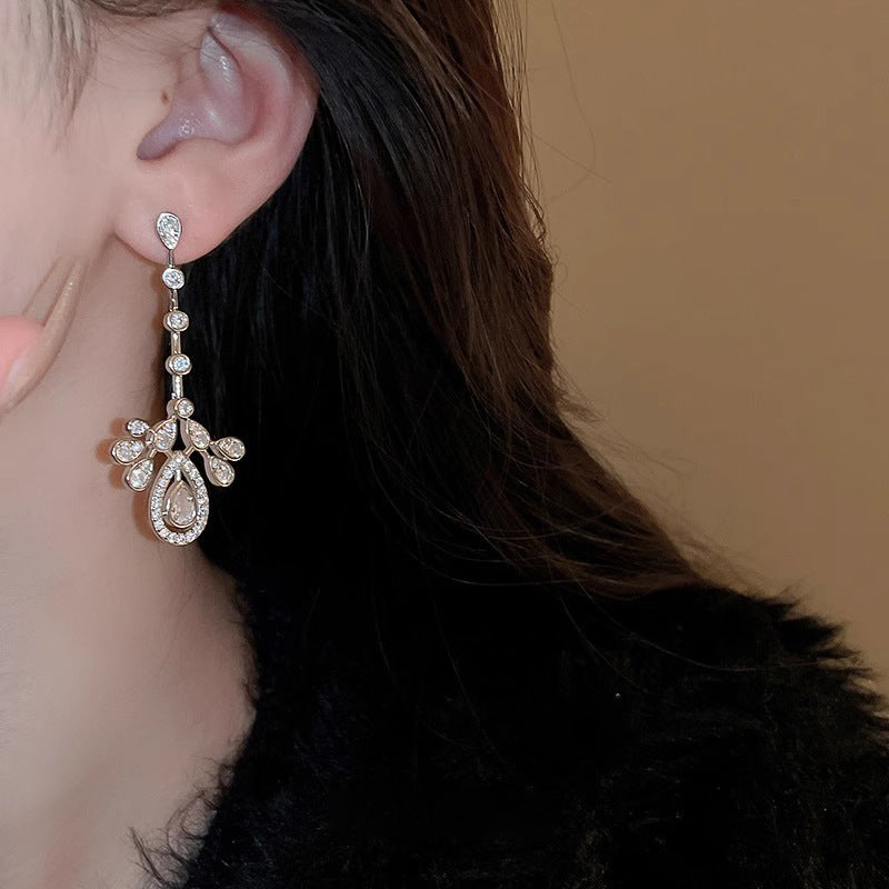 Long silver-tone teardrop cubic zirconia earring worn on the ear