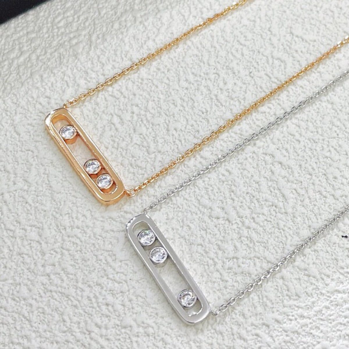 Polished three-stone CZ sliding bar necklaces in rose gold and silver tones