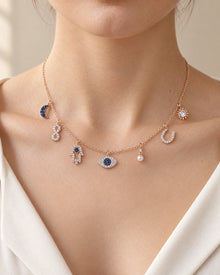 Celestial Evil Eye Multi-Charm Necklace – Rose Gold Tone on a model, seven-charm front view