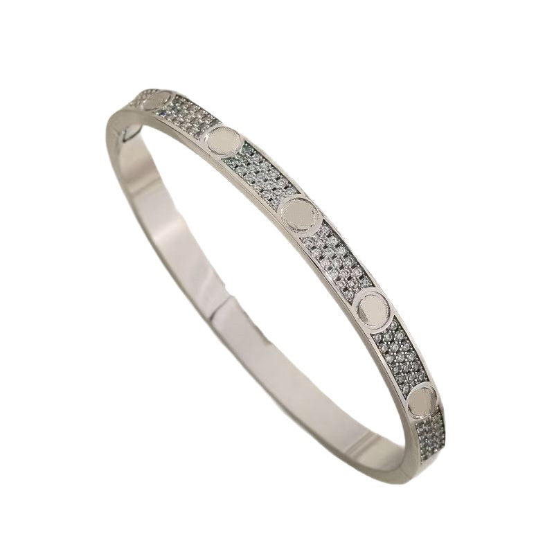 Silver tone cubic zirconia screw motif bangle on white