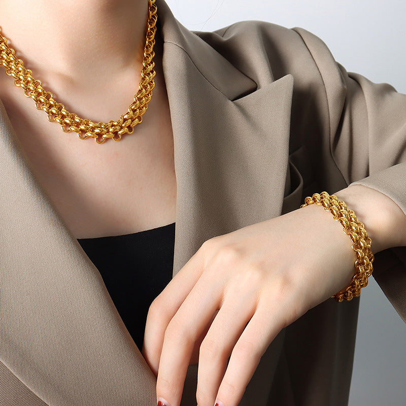 Woman styling a matching gold tone chunky chain necklace and bracelet