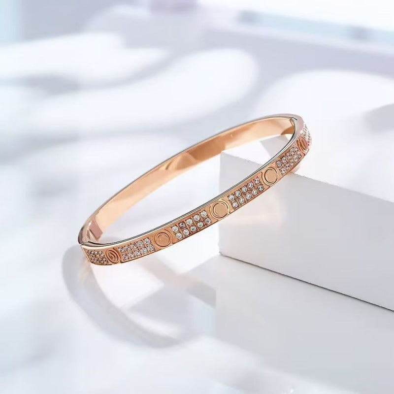Rose gold tone two-row cubic zirconia screw motif bangle