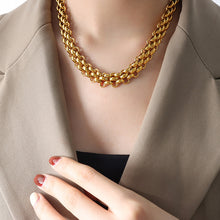 Gold tone chunky toggle chain necklace worn by woman
