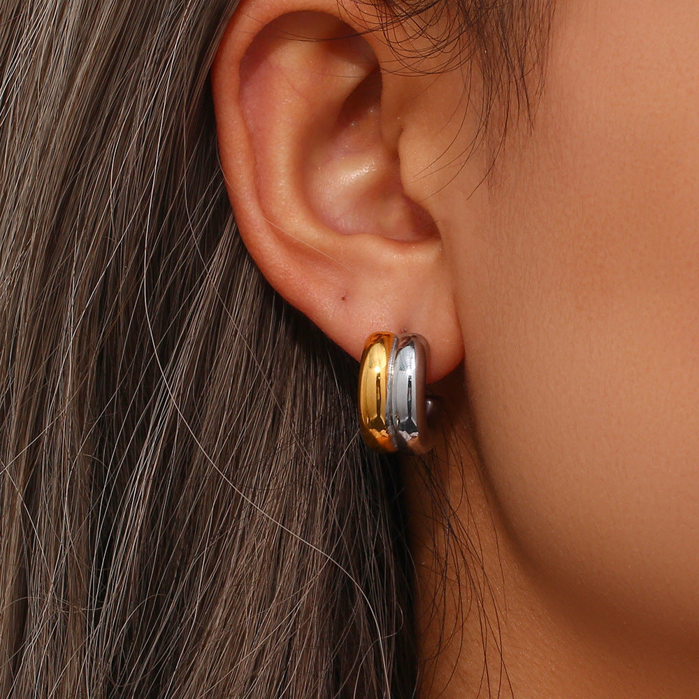 Model wearing two tone stainless steel C-hoop stud earrings