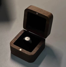 Vintage silver tone compass signet ring displayed in a wooden jewelry box
