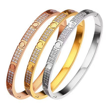 Gold, rose gold and silver tone cubic zirconia screw motif hinged bangles on white