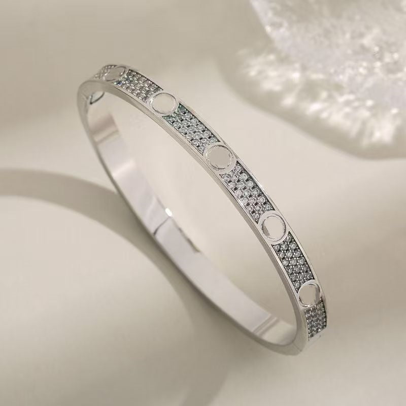 Gold tone pave screw motif bangle close-up