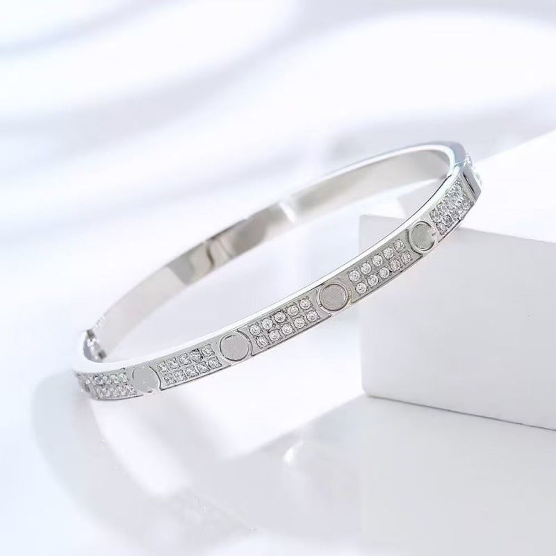 Silver tone two-row cubic zirconia screw motif bangle