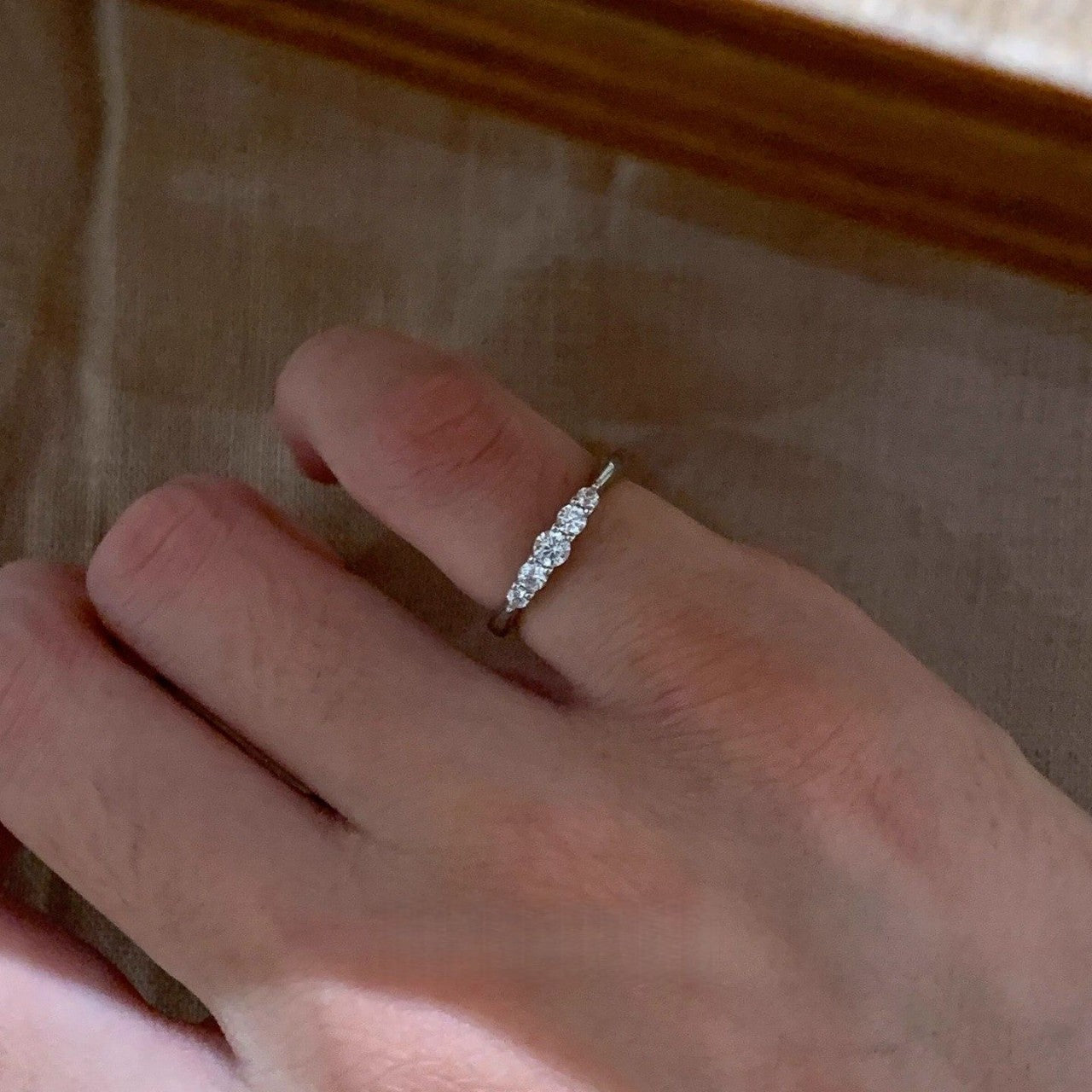 Silver-tone five-stone pinky ring worn on a small finger