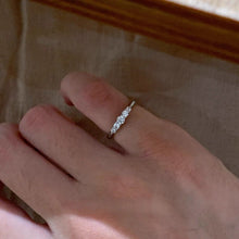 Silver-tone five-stone pinky ring worn on a small finger