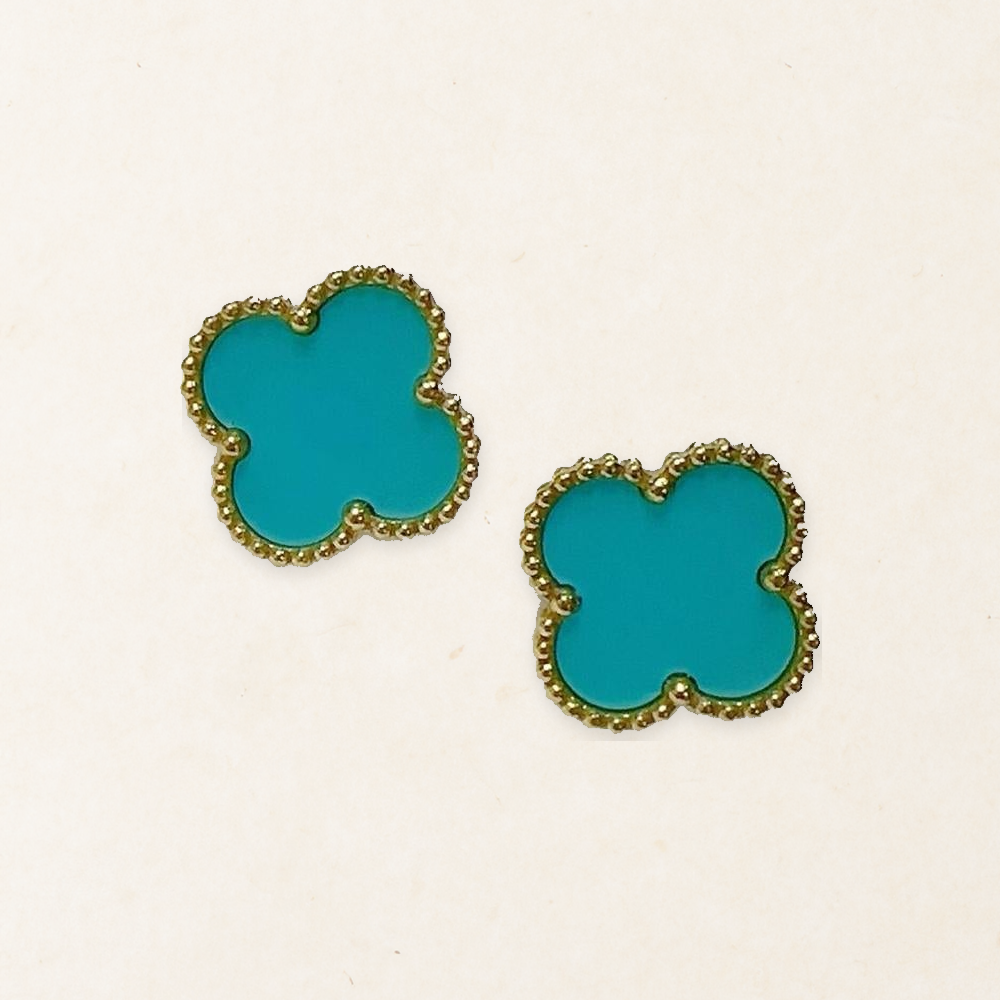 Pair of Aqua Blue four-leaf clover stud earrings with gold-tone beaded borders on a pale paper-texture background.