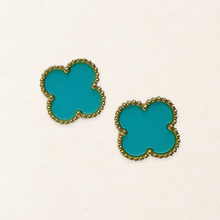 Pair of Aqua Blue four-leaf clover stud earrings with gold-tone beaded borders on a pale paper-texture background.