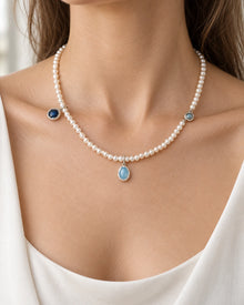 White Beaded Necklace with Blue Drop Charms worn on an adult model